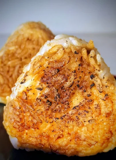 Del animé japonés a la mesa: onigiri de arroz relleno y envuelto en alga nori reta al sushi